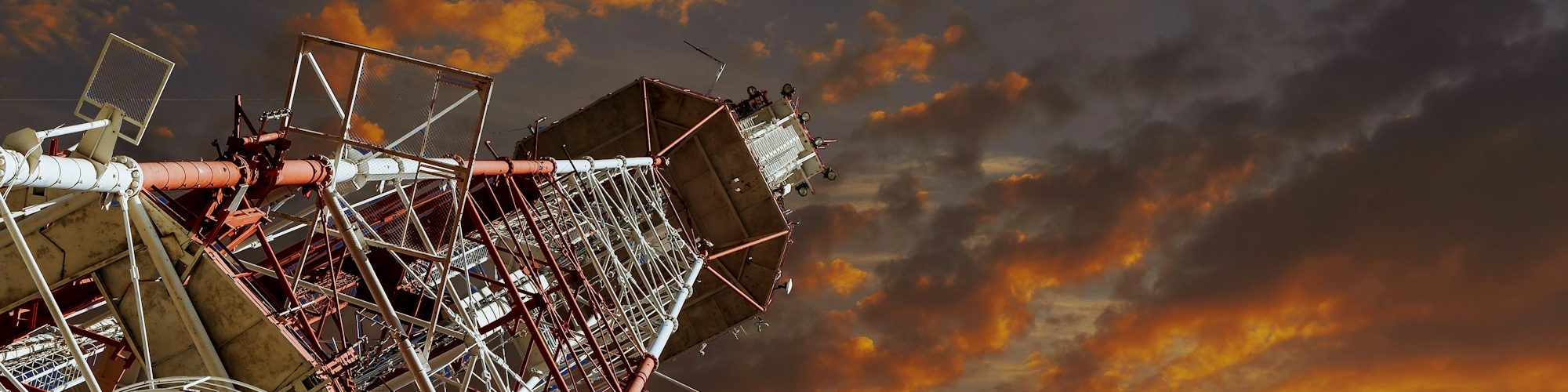 TV tower and plane Telecommunications tower against blue sky, in red and white